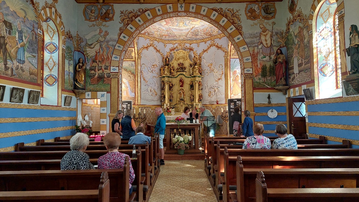Besucher beim Tag der offenen Tür 2024 in der reich verzierten Filialkapelle Wawern – barockes Altarbild, bunte Wandmalereien und Kirchenführungen.