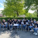 Musikverein Wawern beim Auftritt im Freien – junge Musikerinnen und Musiker mit Instrumenten unter Bäumen bei sonnigem Wetter
