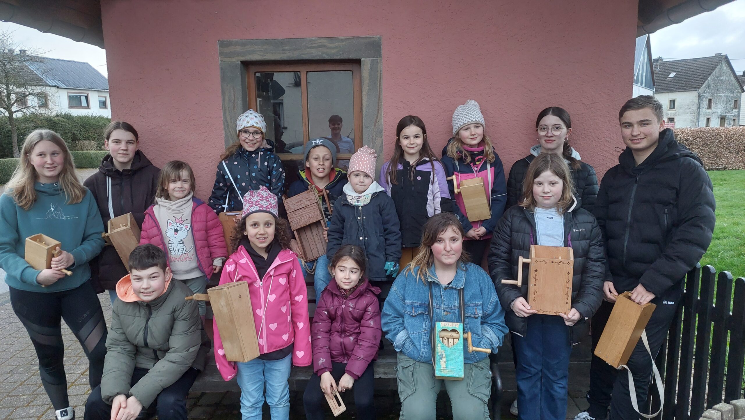 Kinder- und Jugendgruppe aus Wawern mit traditionellen hölzernen Klappern beim Osterbrauch – Gruppenfoto vor dem Gemeindehaus