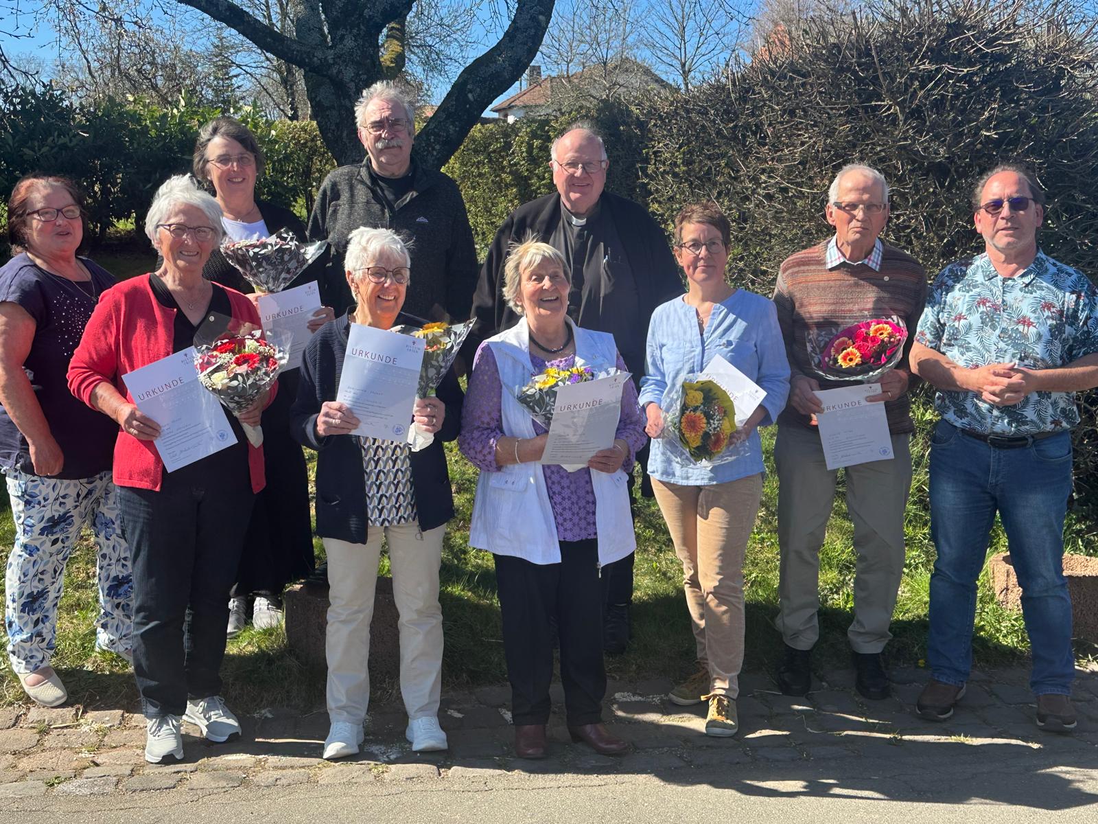 Ehrung von sieben Mitgliedern des Kirchenchors Cäcilia Lasel für 25 Jahre – Gruppenfoto mit Urkunden, Blumen und Pfarrer Georg Müller.